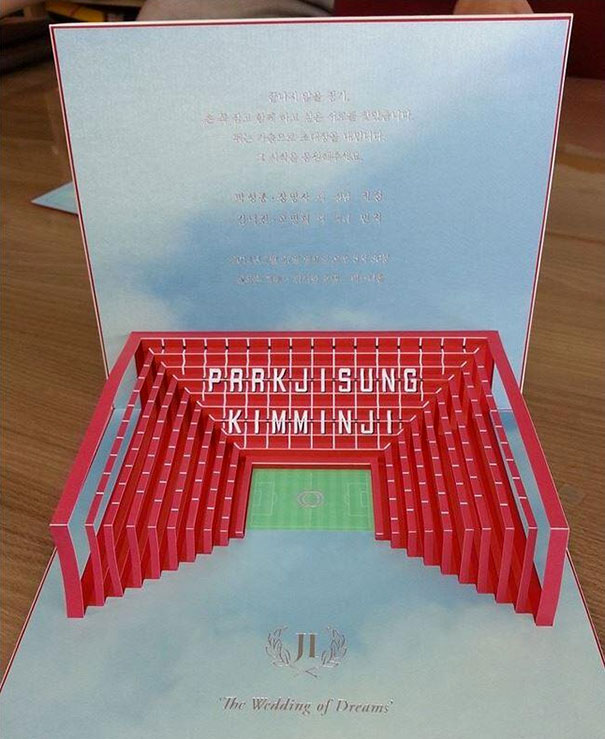 Pop-up wedding invitation featuring a 3D stadium design with names, showcasing creative wedding invitations.