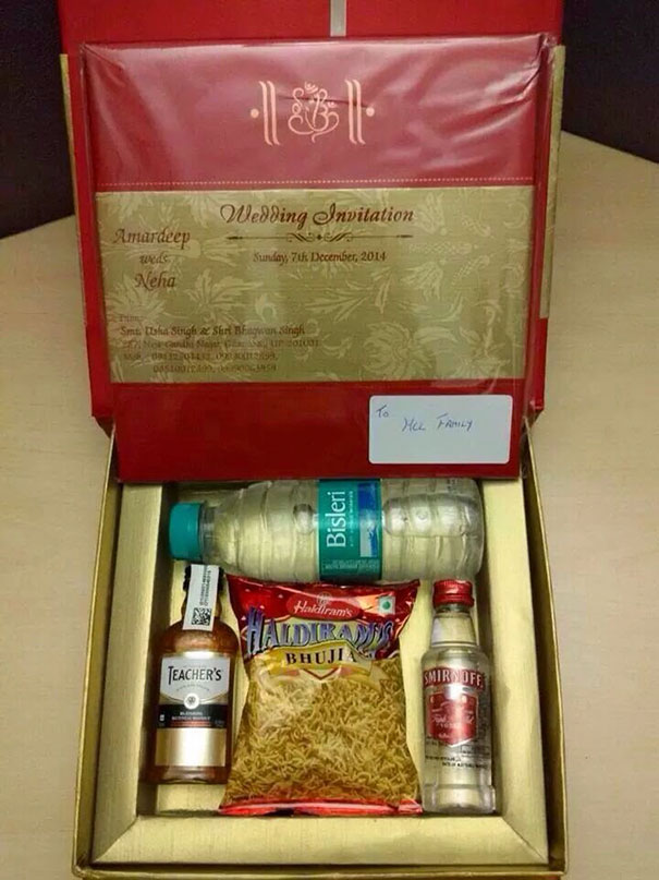 Creative wedding invitation box with snacks, water bottle, and miniature liquor bottles inside for a unique invite idea.