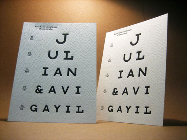 Two creative wedding invitations designed like eye charts with names Julian and Avi Gayil on textured paper.