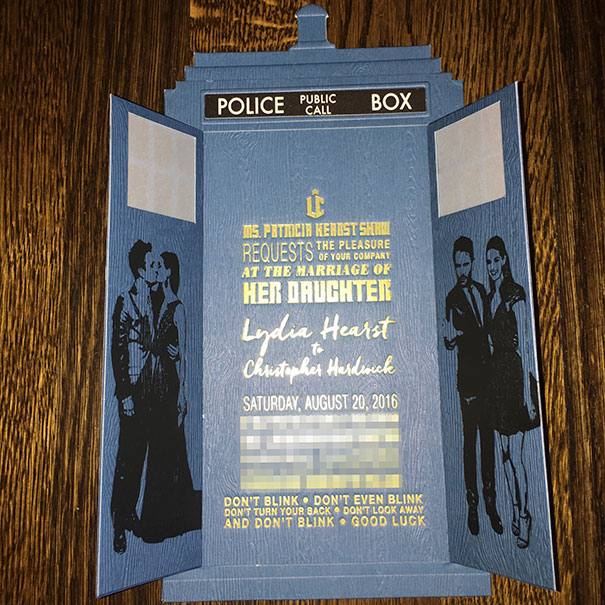 Unique creative wedding invitation designed as a blue police public call box with gold and white text details.