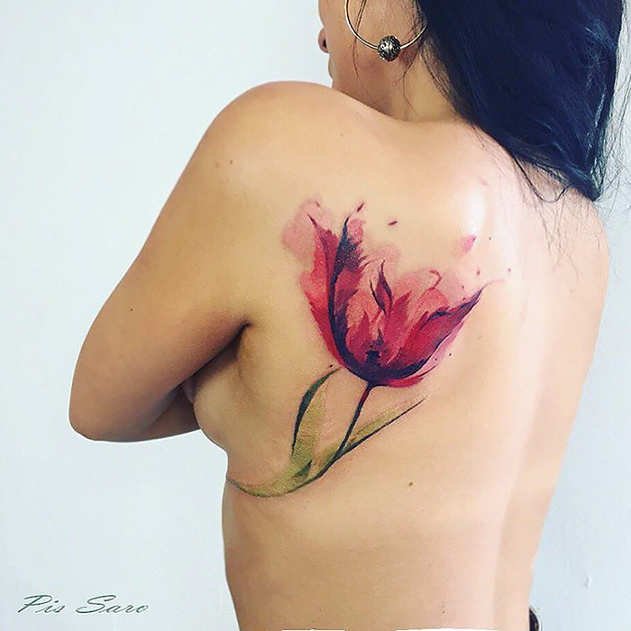 Ethereal nature tattoo of a red flower on a person's back, inspired by changing seasons.