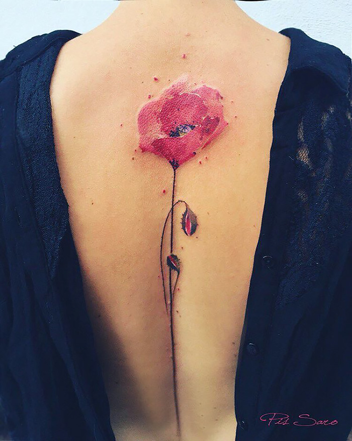 Ethereal nature tattoo of a vibrant red flower on a person's back, symbolizing changing seasons.