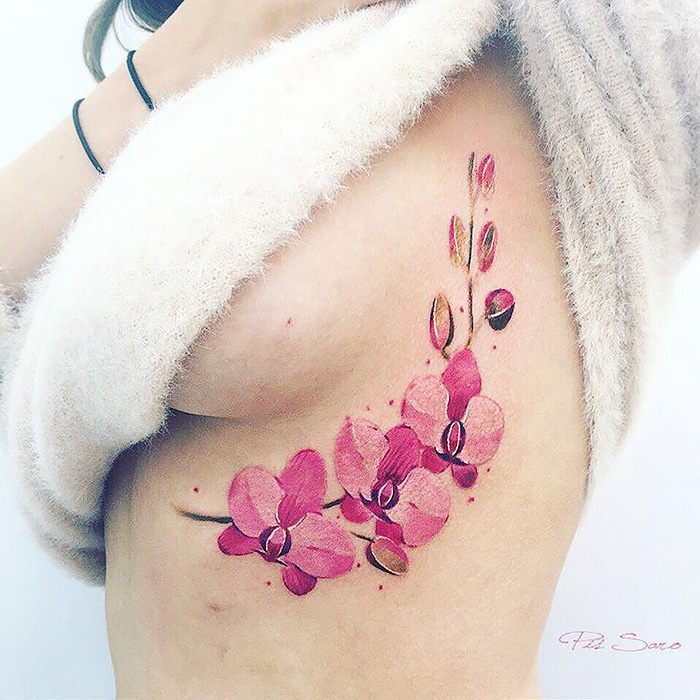 Ethereal nature tattoo of pink flowers on skin, inspired by changing seasons.