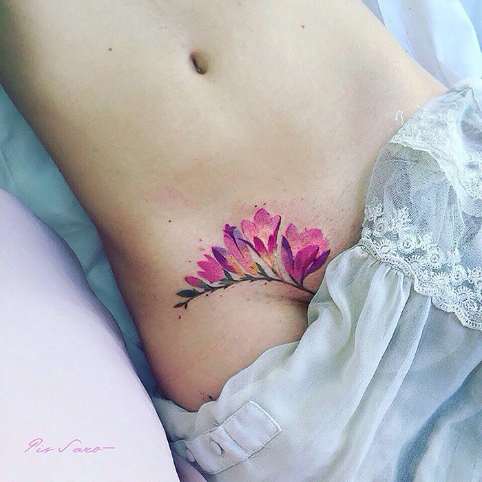 Watercolor flower tattoo on skin, showcasing ethereal nature themes.