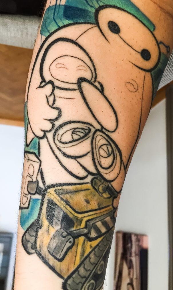 Pixar-inspired tattoo featuring Baymax and WALL-E on a forearm, showcasing colorful and detailed artwork.