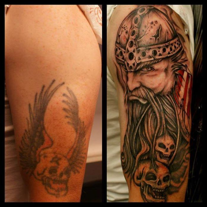 Cover-up tattoo transforming a faded skull with wings into a detailed Viking warrior design.