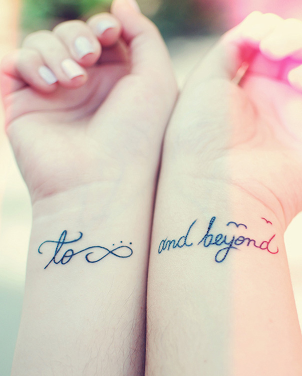 Pixar-inspired tattoo on wrists with "to infinity and beyond" text.