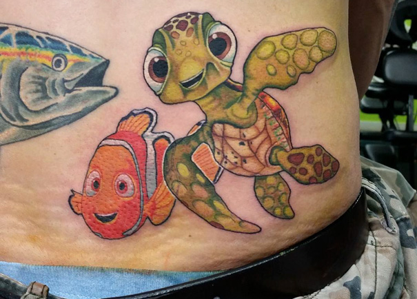 Pixar-inspired tattoo featuring a detailed depiction of a turtle and clownfish on a person's side.