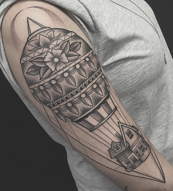 Pixar-inspired tattoo on arm, featuring detailed hot air balloon with house design, black and gray ink.