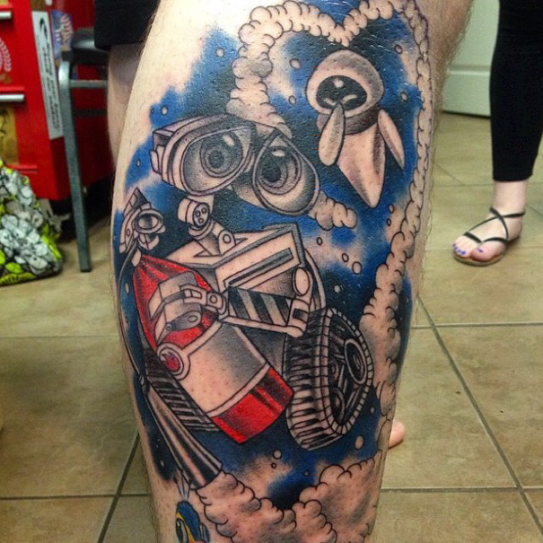 Pixar-inspired tattoo featuring WALL-E and Eve in vibrant colors on a leg.