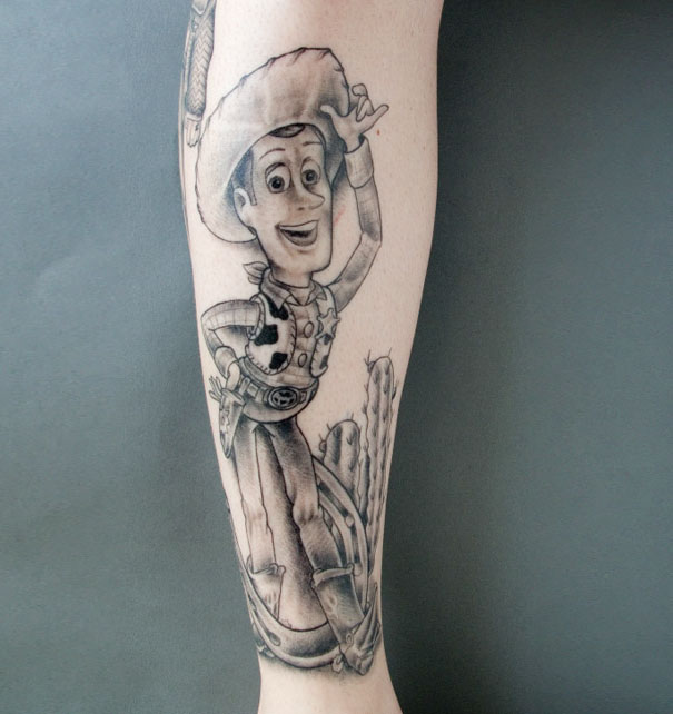 Pixar-inspired tattoo of a cowboy character on a person's forearm, showcasing detailed black and gray shading.