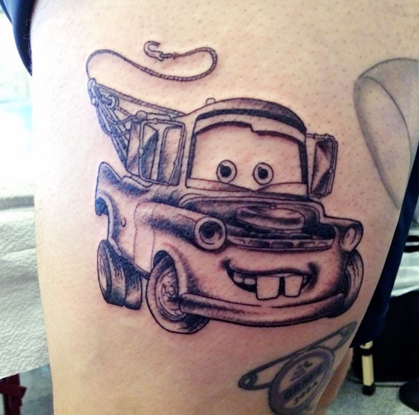 Pixar-inspired tattoo of a smiling tow truck character, sketched on skin with detailed lines and shading.