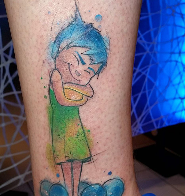 Pixar-inspired tattoo featuring a colorful character design on skin, reflecting vibrant blue and green hues.