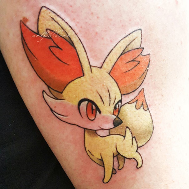 Colorful Pokemon tattoo of Fennekin on skin, featuring vibrant orange and yellow hues.