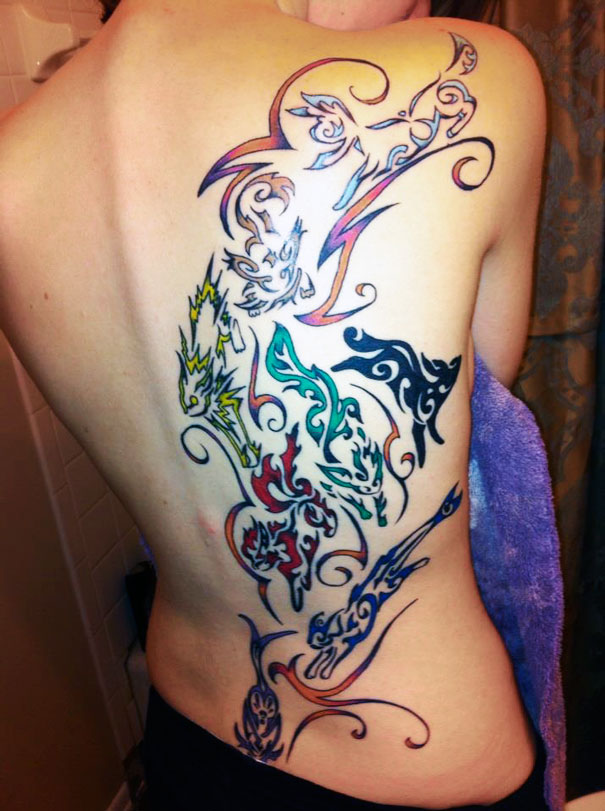 Colorful Pokemon tattoos on a person's back, featuring intricate designs of various creatures.