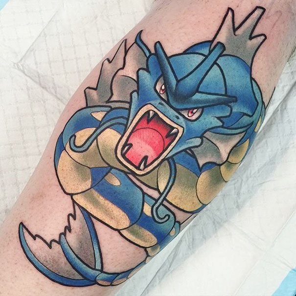 Vibrant Gyarados tattoo on a forearm, showcasing detailed Pokemon artwork for enthusiastic fans.