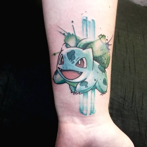 Close-up of Bulbasaur tattoo on forearm, showcasing vibrant colors for Pokemon fans.