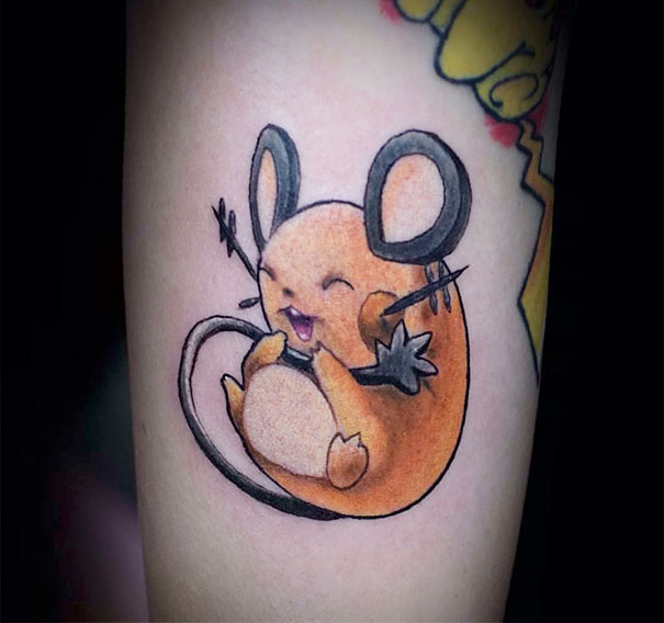 Pokemon tattoo featuring a cute orange and black mouse-like creature with large ears, inked on a forearm.