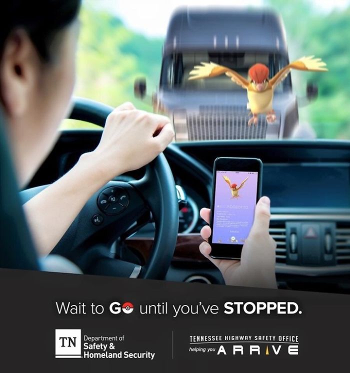 Person playing Pokémon Go while driving, focusing on a smartphone with a Pokémon, highlighting the distraction risk.