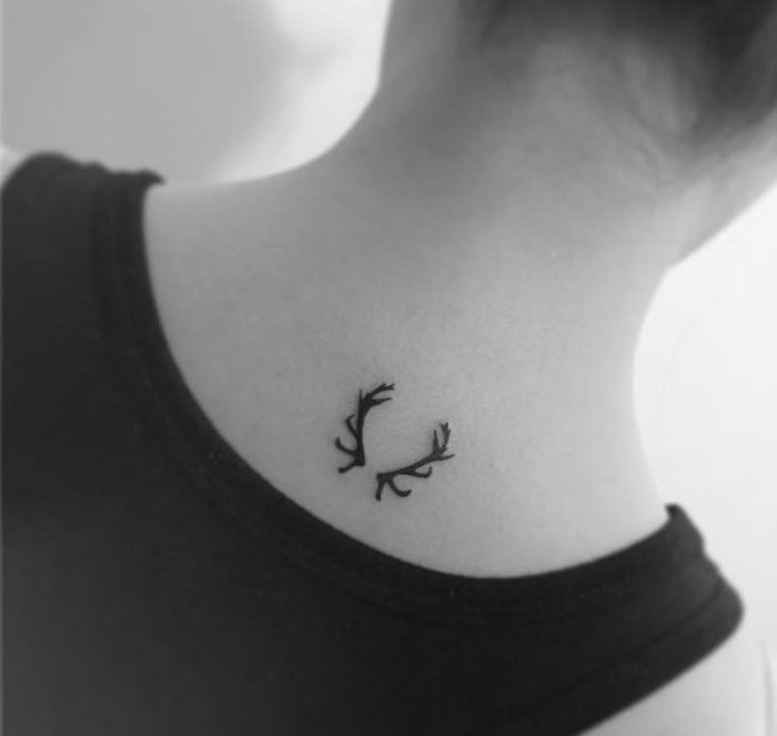 Minimalist tattoo with antler design on neck by Korean artist, showcasing subtle artistry.