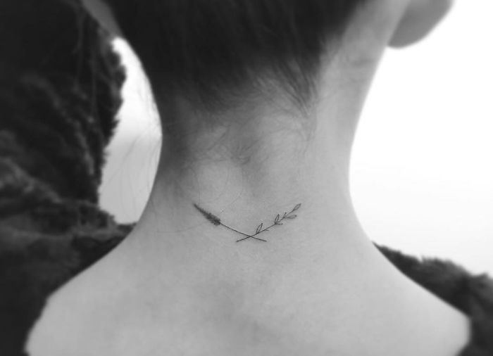 Minimalist tattoo of a delicate branch on the nape, created by a Korean artist.