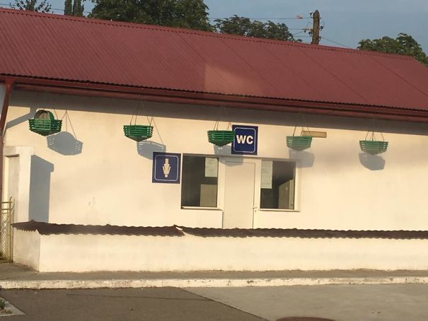 Public restroom with misplaced WC sign above windows; a display of a job fail.