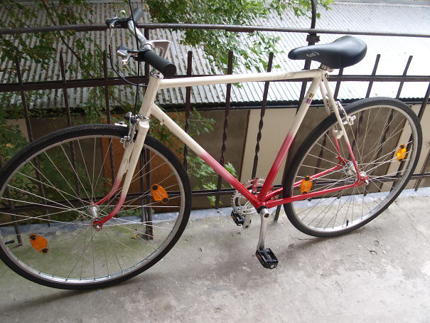 Bicycle with pedals incorrectly attached on one side, illustrating a setup failure.