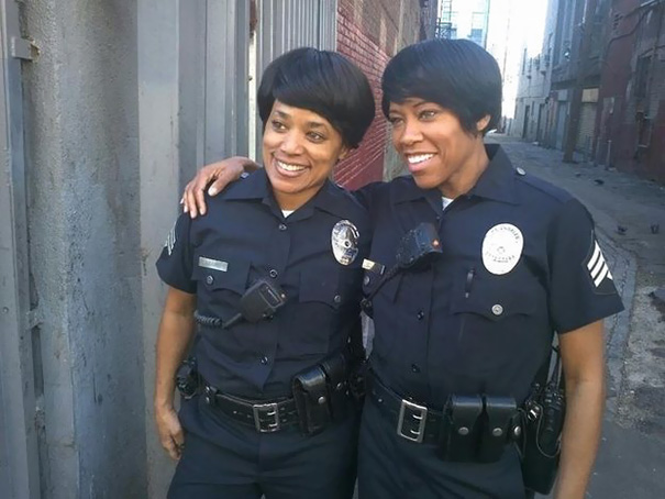 Two women dressed as police officers standing closely in an alley, showcasing celebrity body doubles in Hollywood.