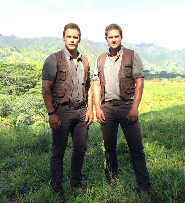Two men dressed alike in outdoor adventure gear standing in a grassy field illustrating Hollywood body doubles concept.