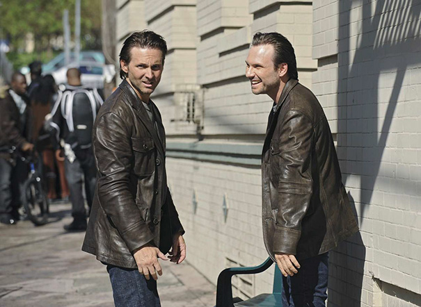 Two men wearing brown leather jackets standing by a sidewalk, illustrating Hollywood celebrities’ body doubles.