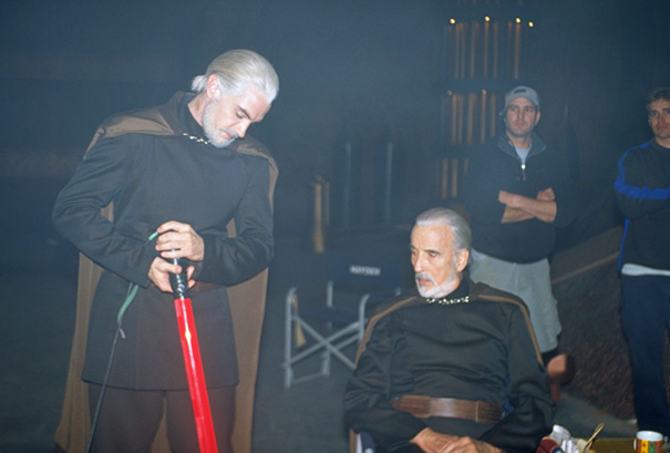 Two men dressed as Star Wars characters with white hair and cloaks, showing Hollywood celebrity body doubles on set.