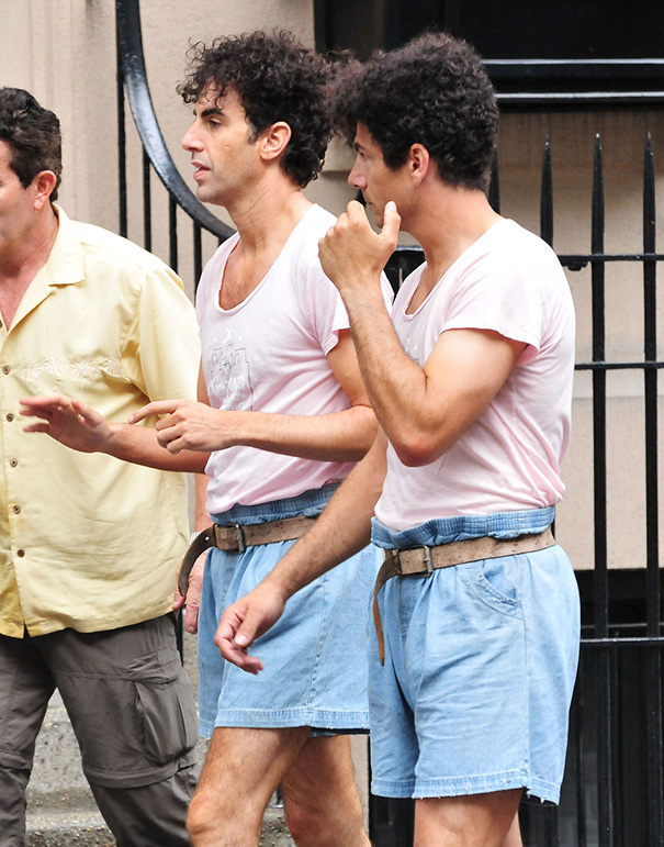 Two men wearing matching outfits resembling celebrity body doubles on a Hollywood street set.