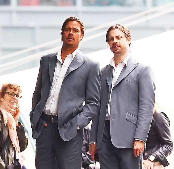 Two men in matching suits standing side by side, illustrating Hollywood celebrities’ body doubles concept.