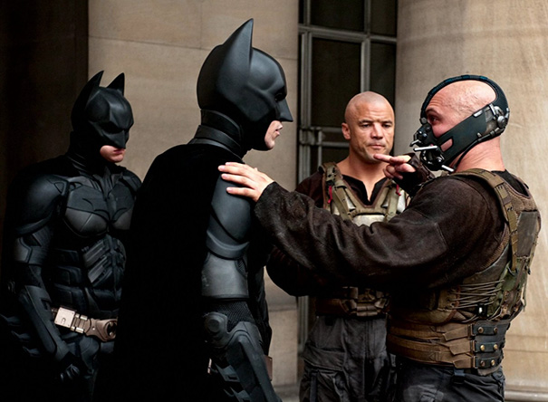 Two Batman characters and actors in tactical gear on set demonstrating body doubles in Hollywood scenes.