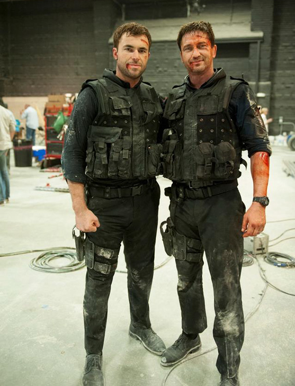 Two men dressed as soldiers, covered in dirt and fake blood, on set illustrating celebrities’ body doubles in Hollywood.