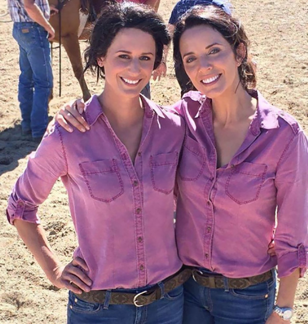 Two women in matching pink shirts and jeans smiling outdoors, illustrating Hollywood celebrities' body doubles.