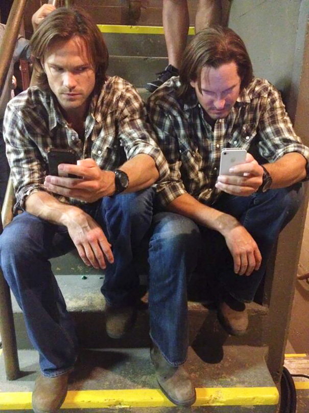 Two men in identical plaid shirts and jeans sitting on stairs, showing celebrities’ body doubles in Hollywood.