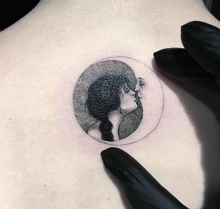 Miniature circle tattoo by Turkish artist Eva Krbdk, depicting a detailed portrait inside a circular frame.