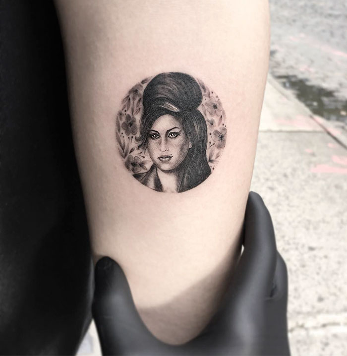 Miniature circle tattoo of a woman's portrait on an arm by Turkish artist Eva Krbdk.