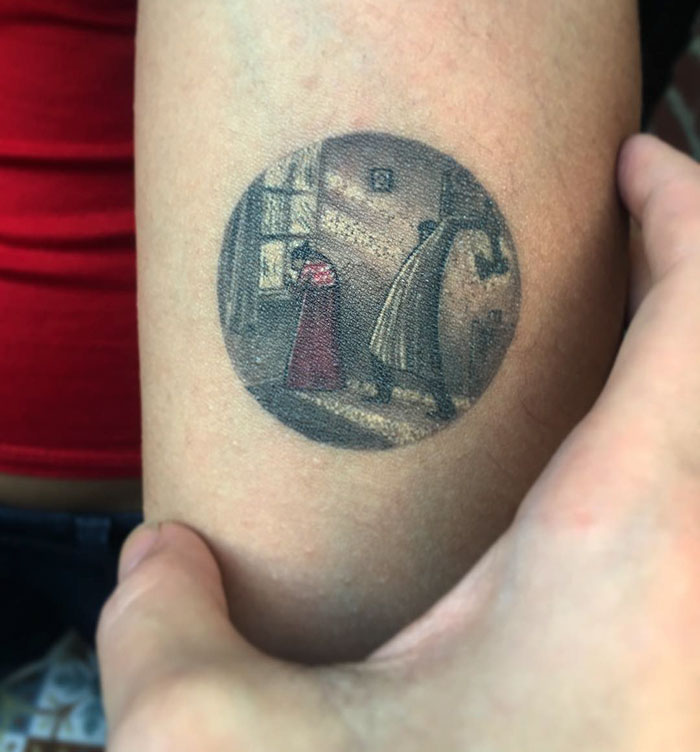 Miniature circle tattoo depicting a vintage scene, created by Turkish artist Eva Krbdk on a person's arm.