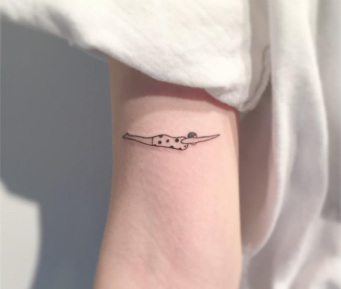 Minimalist tattoo by a Korean artist, featuring a simple, elegant design on an arm.