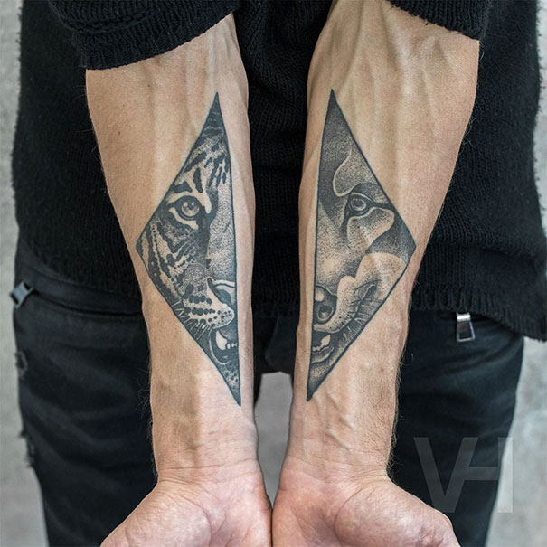 Symmetrical tattoos of a tiger and a wolf on forearms, blending nature and geometry.