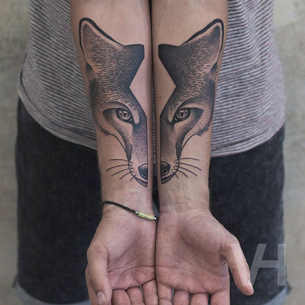 Symmetrical tattoos on forearms depicting a fox, showcasing the balance between nature and geometry.