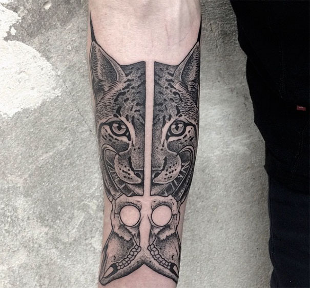 Symmetrical tattoo by Valentin Hirsch on forearm, featuring a lynx and geometrics, balancing nature and geometry.