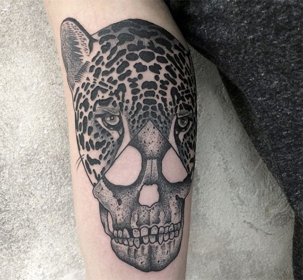 Symmetrical tattoo combining a jaguar and skull, showcasing nature and geometry balance.