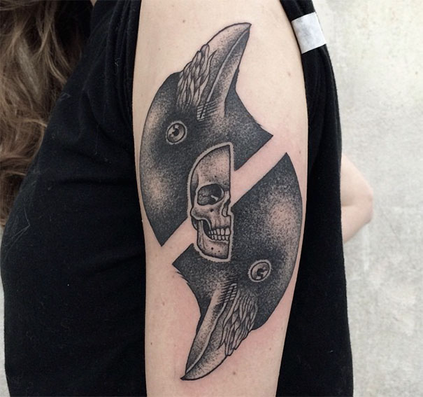 Symmetrical tattoo by Valentin Hirsch featuring a skull and bird motifs, blending nature with geometric design.