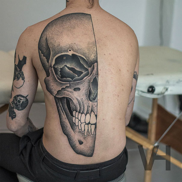 Symmetrical tattoo of a skull on a person's back, blending nature and geometry, by Valentin Hirsch.