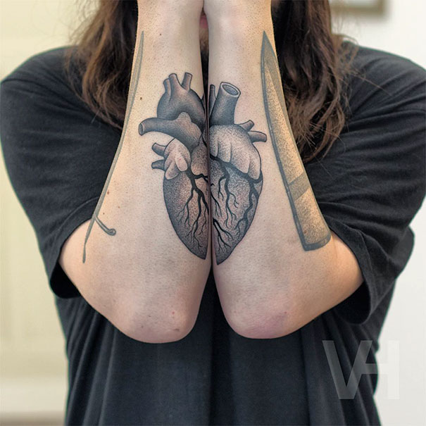 Symmetrical tattoos of a heart on forearms, blending nature and geometry in Valentin Hirsch style.