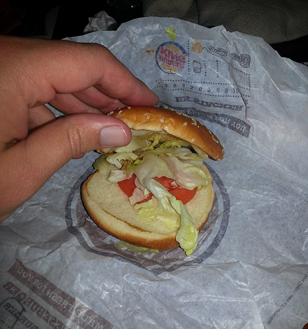 Burger missing patty exemplifying job fail, with lettuce and tomato on a bun.