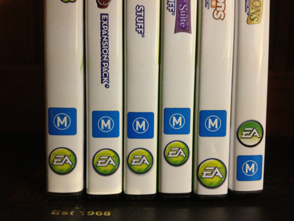 Misaligned DVD boxes on a shelf, showcasing EA games with incorrect label placements.